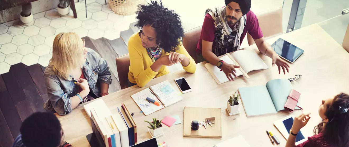 Overhead view of group of workers around a conference table